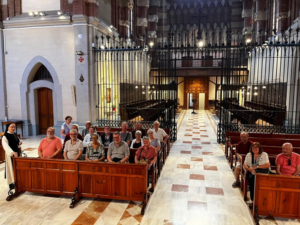 Entitats del Baix Llobregat i visitants a punt de començar la visita a l'església